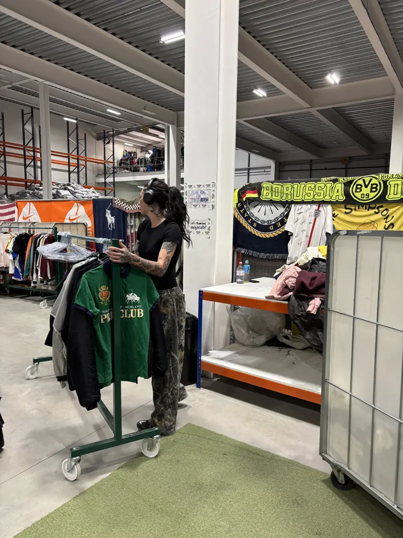 Hanging vintage shirts on a rail in a warehouse